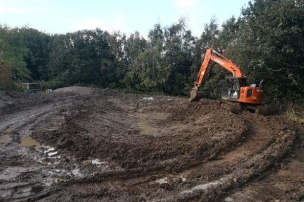 Brookhill Pond site restoration project. Buckley. Digger with ground cleared and pond ditch dug.