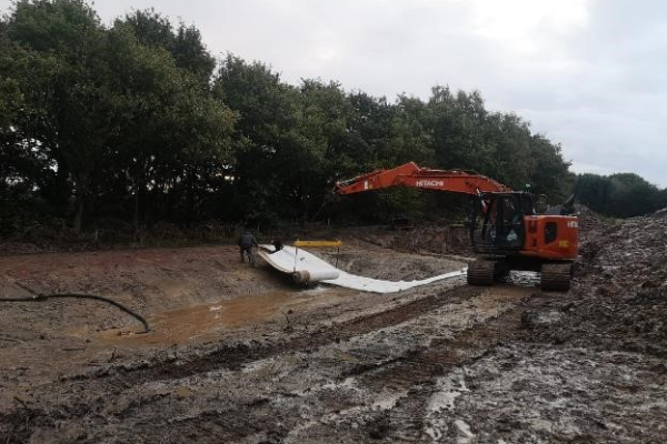 Brookhill Pond site restoration project. Buckley. Laying pond waterproofing.