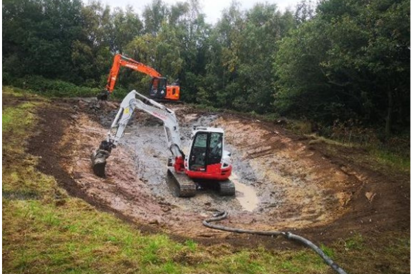 Brookhill Pond site restoration project. Buckley. Two diggers in the empty pond cavity.
