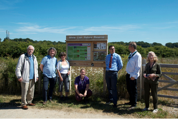 Members of Building Wildlife and ARC in front of the new White Lion Nature Reserve sign in Penymynydd